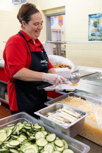 A staff member serves pears